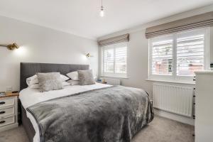 a bedroom with a large bed and two windows at Pass the Keys Perfectly presented house in Sevenoaks