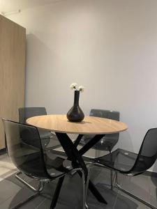 a wooden table with a vase with flowers on it at Paisible Duplexe sur Villeneuve d ascq in Annappes