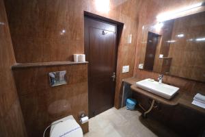 een badkamer met een toilet, een wastafel en een spiegel bij Bansi Home Stay in Agra