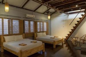 two beds in a room with a staircase at Mori Jonker in Malacca