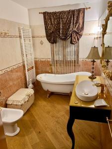 蘭佐丁泰維的住宿－Villa Marzia，带浴缸、卫生间和盥洗盆的浴室
