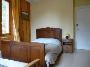 a bedroom with a bed and a nightstand and a window at L'Horizon des Alpes in Le Petit-Bornand-lès-Glières
