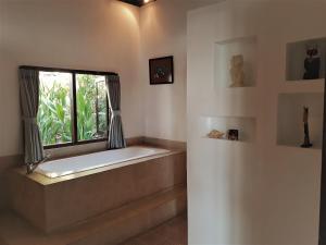 a bath tub in a room with a window at Anda Amed Villas & Spa in Amed +37 photos