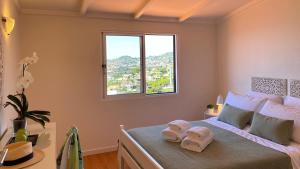 1 dormitorio con 1 cama con 2 toallas en Casa ideal para famílias com vista mar desafogada, en Funchal