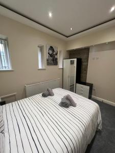 un dormitorio con una cama con dos animales de peluche en Edgerton Suites, en Huddersfield