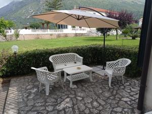 a patio with a table and chairs and an umbrella at La casa Bianca in Maratea
