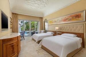 Habitación de hotel con 2 camas y TV en Crowne Plaza Resort Sanya Bay, an IHG Hotel, en Sanya