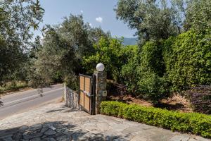 una puerta al lado de una carretera con arbustos en Villa 10 Elies, en Koropi