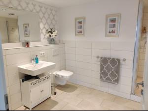 La salle de bains blanche est pourvue d'un lavabo et de toilettes. dans l'établissement Ferienwohnung Fanny, à Dresde