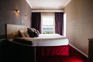 um quarto com uma cama grande e uma janela em Hotel De Normandie em Saint Helier