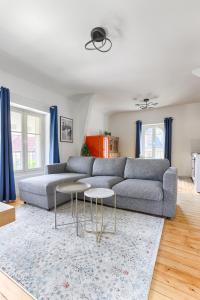 uma sala de estar com um sofá cinzento e duas mesas em Appartements de l'Abbaye - A 10 minutes de Disneyland em Lagny