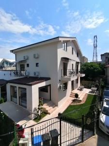 a white house with a balcony and a car at Casa di Sonia in Eforie Nord