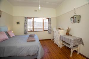 a bedroom with a bed and a dresser and a window at Sea Breeze Stay in East London