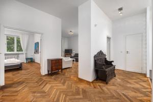 sala de estar con paredes blancas y suelo de madera. en Marszałkowska 18 by Homeprime en Varsovia