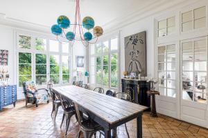 a dining room with a wooden table and chairs at La Villa Lauvray in Vétheuil