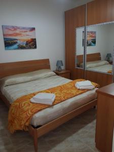 - une chambre avec un lit et 2 serviettes dans l'établissement Kamarinè - sul mare, à Scoglitti