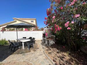 eine Terrasse mit einem Tisch, Stühlen und Blumen in der Unterkunft Grande maison à 5min de la plage in Canet-en-Roussillon