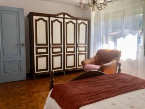 een slaapkamer met een bed, een stoel en een raam bij Apartamento céntrico en la playa de Bueu in Bueu