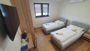 een kamer met 2 bedden en een flatscreen-tv bij Ski & Wake Resort Těrlicko in Dolní Těrlicko