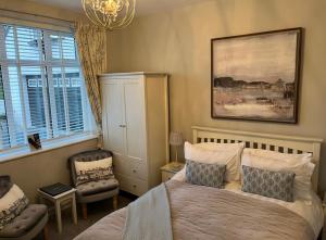 a bedroom with a bed and a chair and a chandelier at Castellor Bed & Breakfast in Cemaes Bay