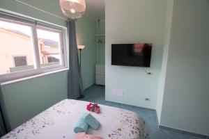 a room with a bed with a window and a tv at Appartamento Sogno Marino in Portoferraio