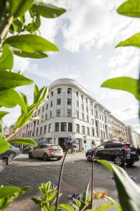 a large white building with cars parked in front of it at Luxury studio with a park view in Rīga