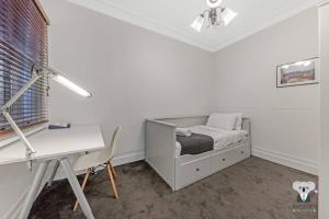 a white bedroom with a bed and a desk at Glebe Cozy 2 Bedroom Stunning Terrace House / NGL058 in Sydney