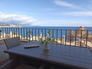 a table on a balcony with a view of the ocean at ADNANIa 2023 in La Herradura
