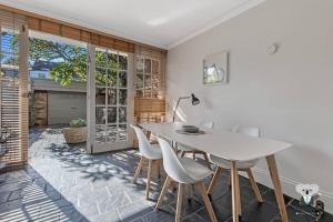 a dining room with a white table and chairs at Glebe Cozy 2 Bedroom Stunning Terrace House / NGL058 in Sydney
