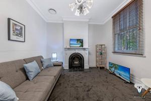 a living room with a couch and a fireplace at Glebe Cozy 2 Bedroom Stunning Terrace House / NGL058 in Sydney