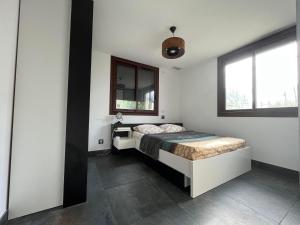 een slaapkamer met een bed en 2 ramen bij Grande maison à 5min de la plage in Canet-en-Roussillon