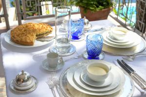 a table with plates and cups and a cake on it at Villa Ripe Rosse Suites&Sea in Montecorice
