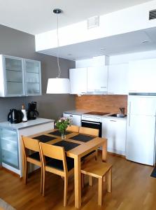 een keuken met een tafel en stoelen en witte kasten bij Laatuhuoneisto Saimaa näkymällä- Luxury apartment by lake Saimaa in Imatra