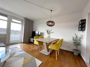 uma sala de jantar com uma mesa e cadeiras amarelas em Beautiful 2-room apartment with balkony in Willich em Willich