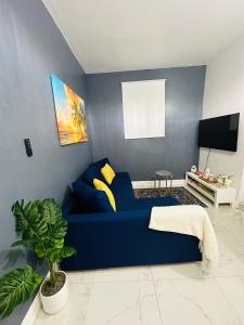 a blue couch in a living room with a tv at Cozy Guest House 1.9 miles from Hard Rock Stadium in Miami Gardens
