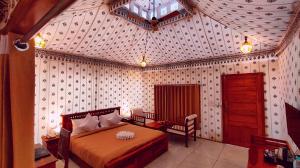 a bedroom with a bed and a table and a chair at The Sky Imperial Nakoda Green Valley Resort in Nāthdwāra