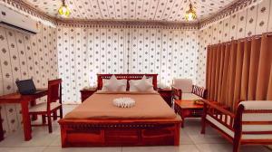 a bedroom with a bed with two chairs and a desk at The Sky Imperial Nakoda Green Valley Resort in Nāthdwāra