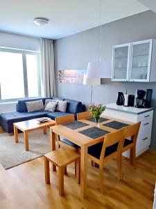 a living room with a table and a blue couch at Laatuhuoneisto Saimaa näkymällä- Luxury apartment by lake Saimaa in Imatra