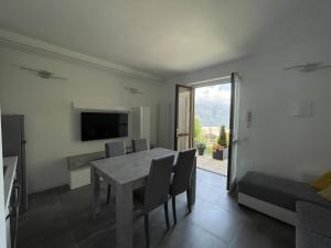 a dining room with a table and chairs and a television at IseoLakeRental - Casa Il Nido in Fonteno