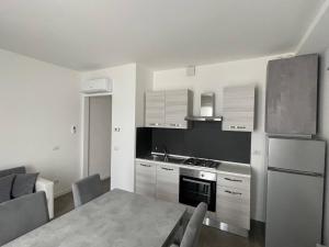 a kitchen with a table and a stove and a refrigerator at IseoLakeRental - Casa Il Nido in Fonteno