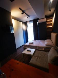 Green home Saburtalo في تبليسي: غرفة فيها سرير وطاولة فيها