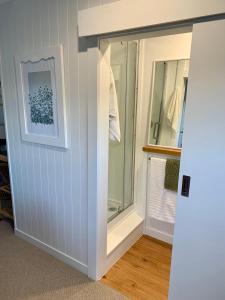 a room with a glass door leading into a bathroom at Magnolia Studio in Hastings