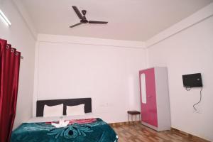 1 dormitorio con 1 cama y ventilador de techo en Chang Ghar Resort en Kāziranga