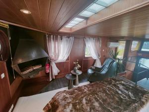 - une chambre dans un bateau avec un lit et une chaise dans l'établissement Peniche relaxant, à Sèvres
