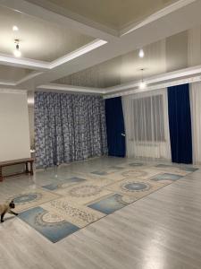 a room with a stage and a cat sitting on the floor at Гостевой Домик Жайлау in Taraz