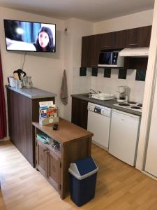 a small kitchen with a tv on the wall at Appartement 4 personnes aux pieds des pistes, Ariège in Ustou