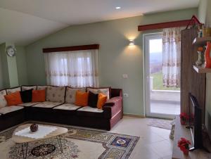 a living room with a couch and a large window at Beautiful 1-Bed House in Korce in Korçë