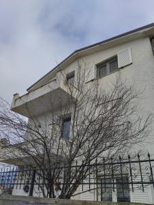 un edificio con un árbol delante de él en Beautiful 1-Bed House in Korce, en Korçë