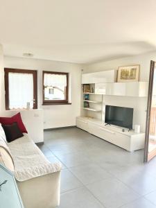 Una sala de estar con un sofá y un televisor. en CASA MARILU', en Castello di Fiemme