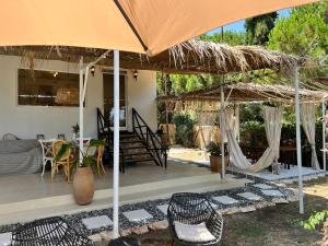 a patio with an umbrella and chairs and a table at My Ancient Pydna Paradise ! in Makrygialos